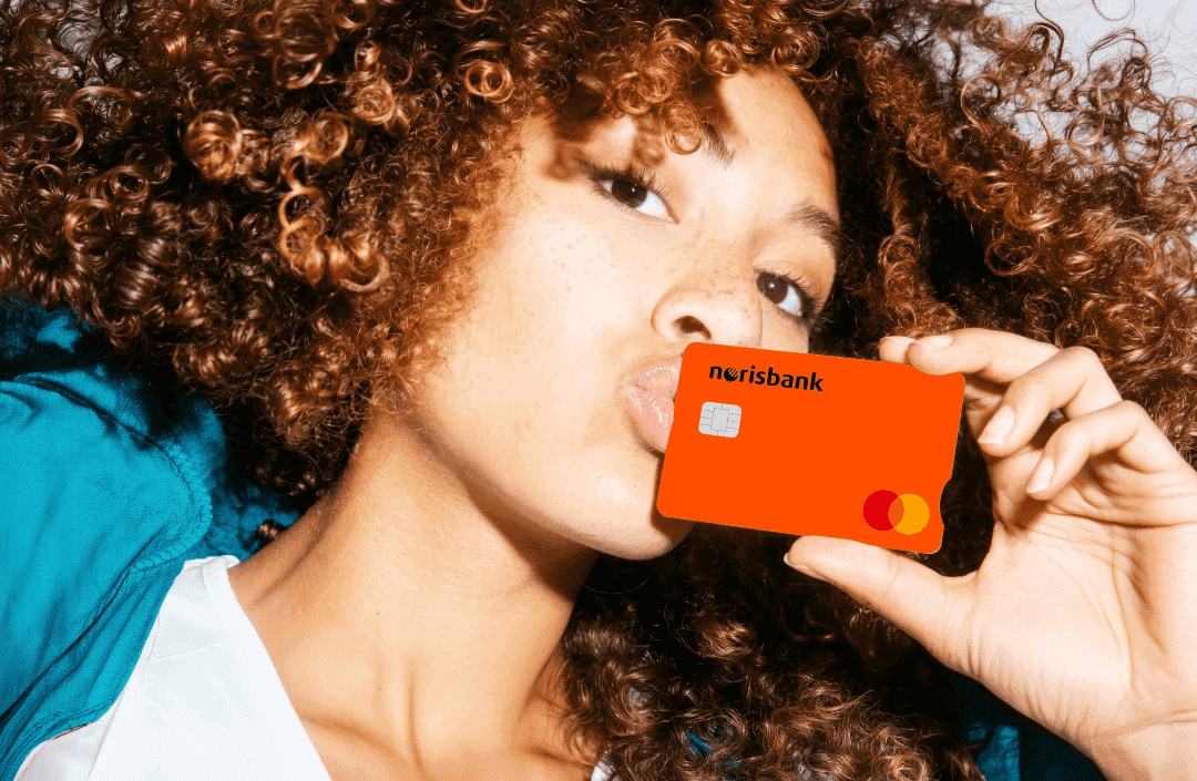 Frau mit lockigem Haar küsst norisbank Karte: modernes Finanzmotiv für ein kostenloses Girokonto.