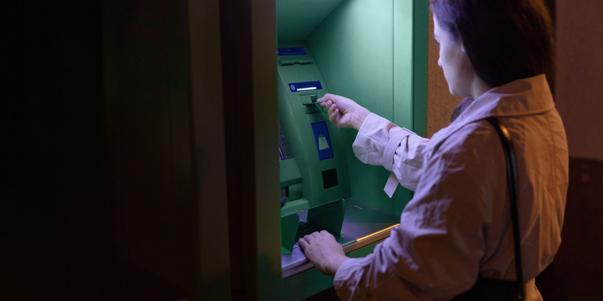 Eine Frau hebt Bargeld am Geldautomaten ab.