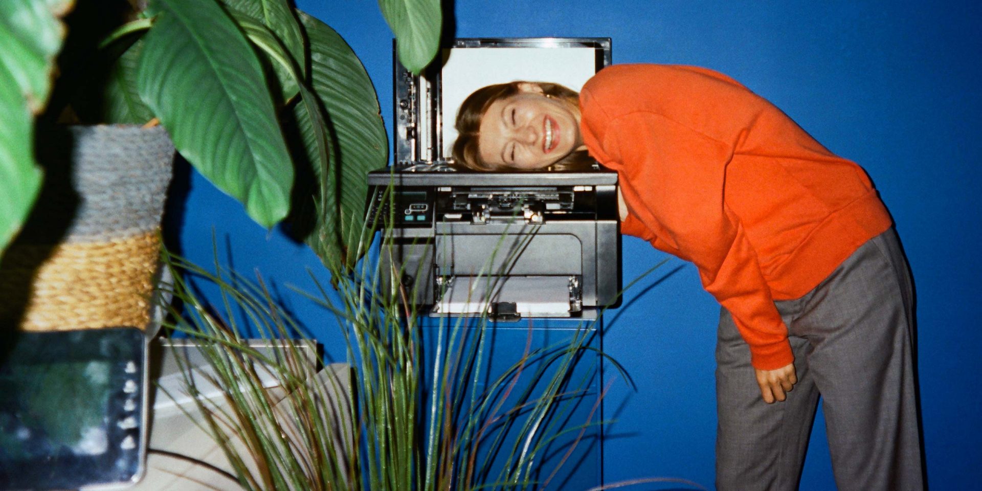 Junge Frau legt ihren Kopf auf einen Kopierer. Symbolbild für "Berufseinstieg Tipps"