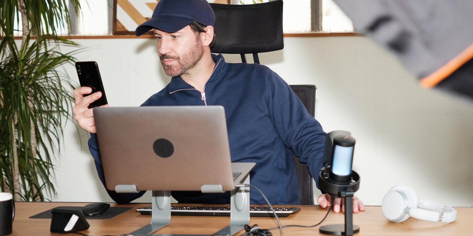 Junger Mann checkt per Smartphone seine Bitcoin-Anlage. Symbolbild für "Bitcoin Definition".