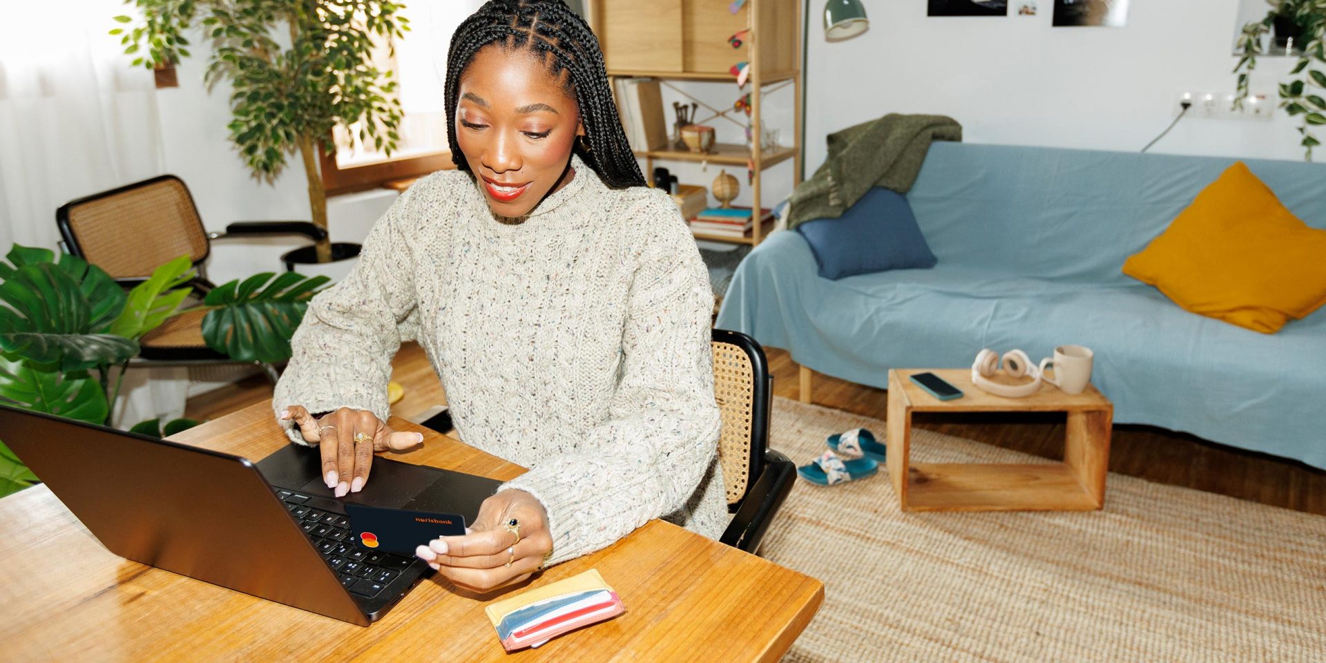 Frau am Schreibtisch beim Online-Shopping. Sie benutzt ihre Kreditkrate und gibt die CVC Prüfnummer ein.