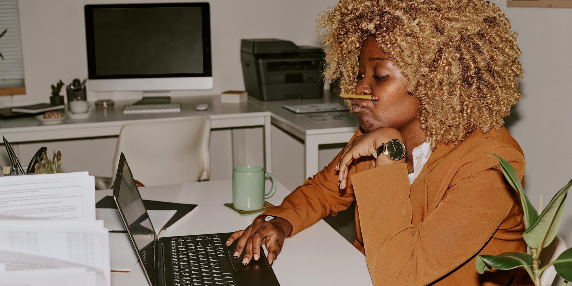 Frau sitzt in einem Büro am Laptop und recherchiert zum Thema Kreditvoraussetzungen.