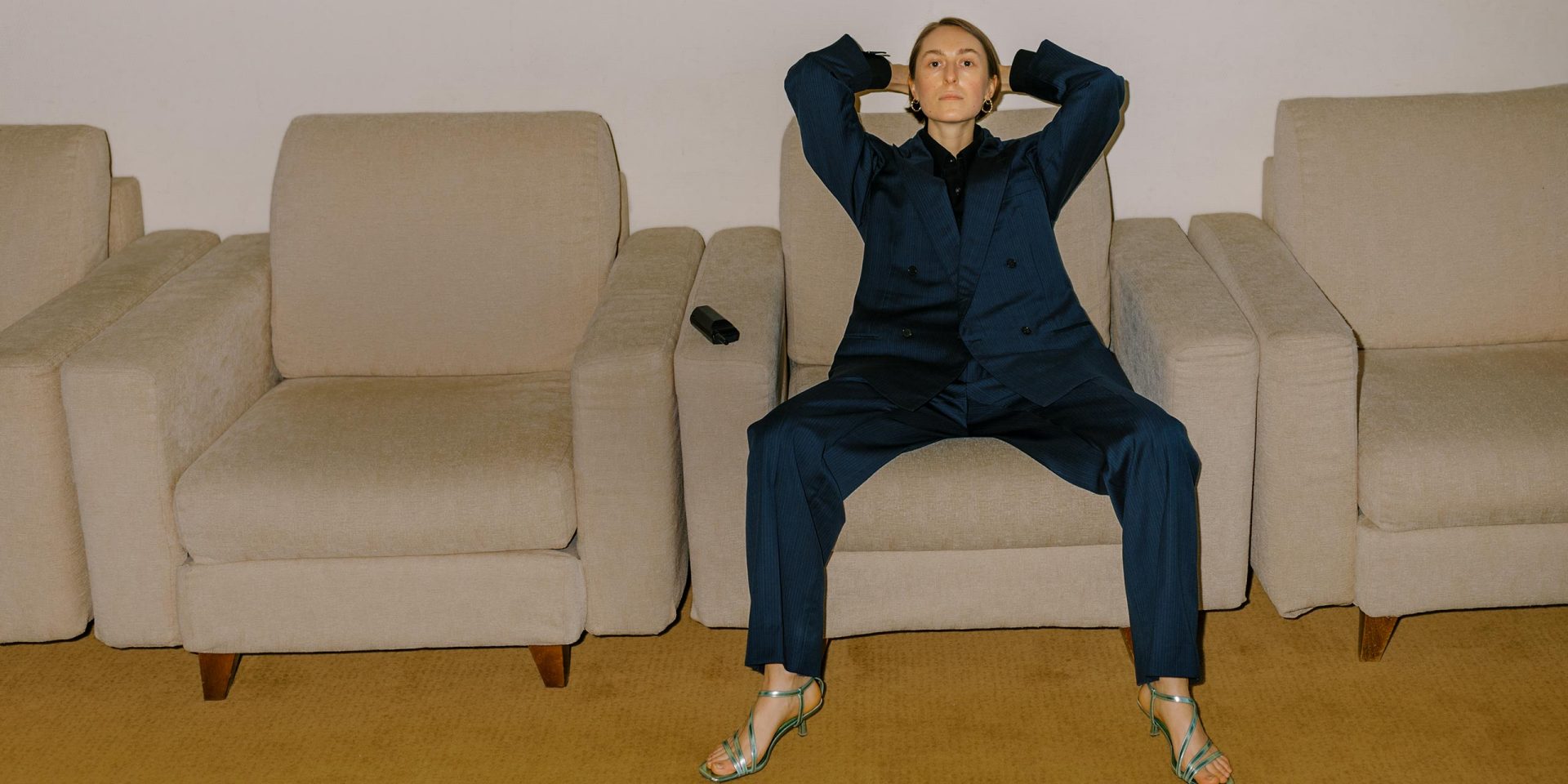 Eine Frau sitzt in dominanter Pose im Business-Outfit auf einem Sessel – sie ist zufrieden mit ihrer Entscheidung für ein norisbank Business-Konto.