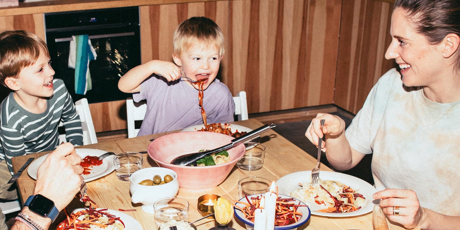 Familie beim Essen. Symbolbild für "ab welchem Alter kann ein Kind ein Girokonto haben".