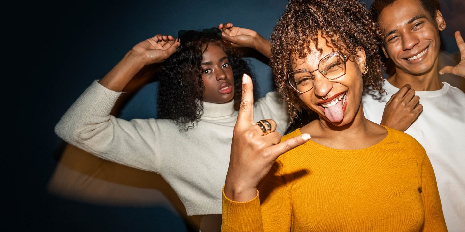 Drei fröhliche Jugendliche in Partystimmung freuen sich über das Girokonto für junge Leute.