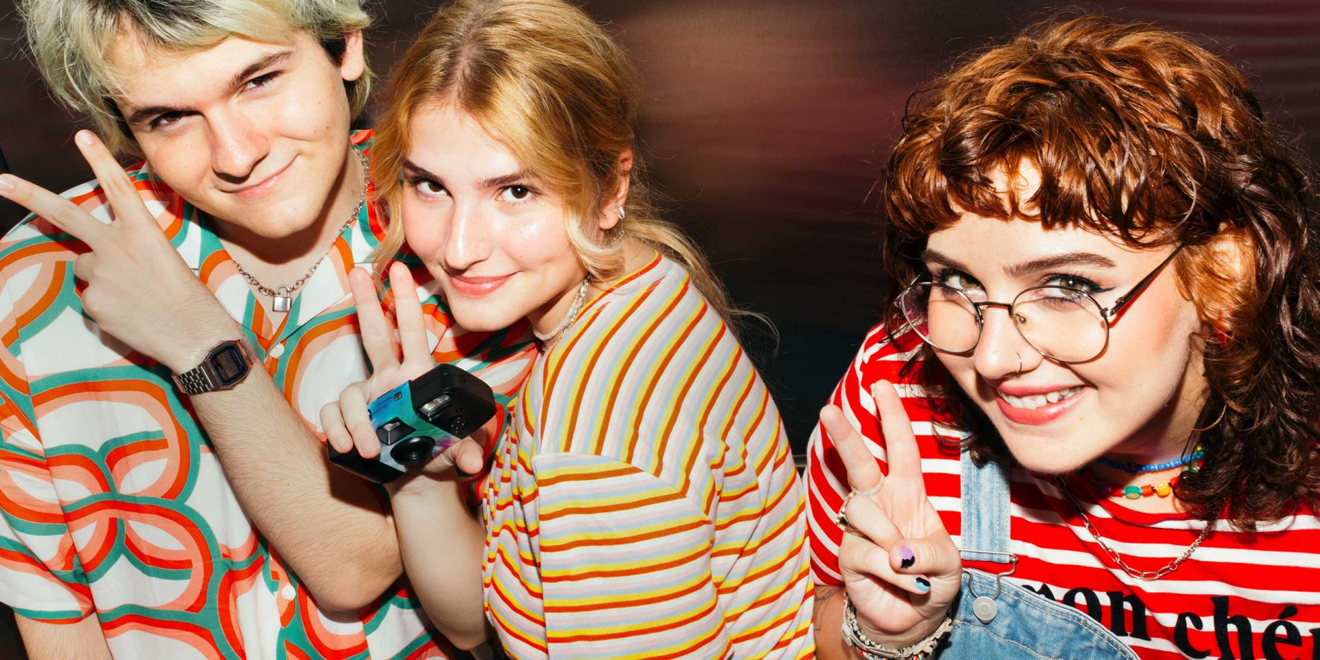 Drei lächelnde Jugendliche nebeneinander freuen sich über das Jugendkonto.