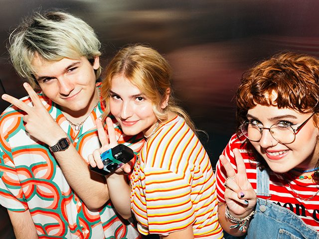 Drei lächelnde Jugendliche nebeneinander freuen sich über das Jugendkonto.