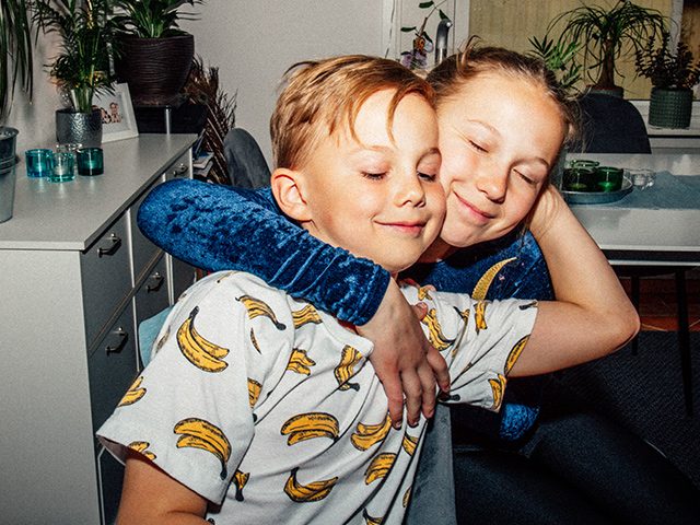 Zwei fröhliche Kinder umarmen sich liebevoll und freuen sich über das Kinderkonto.