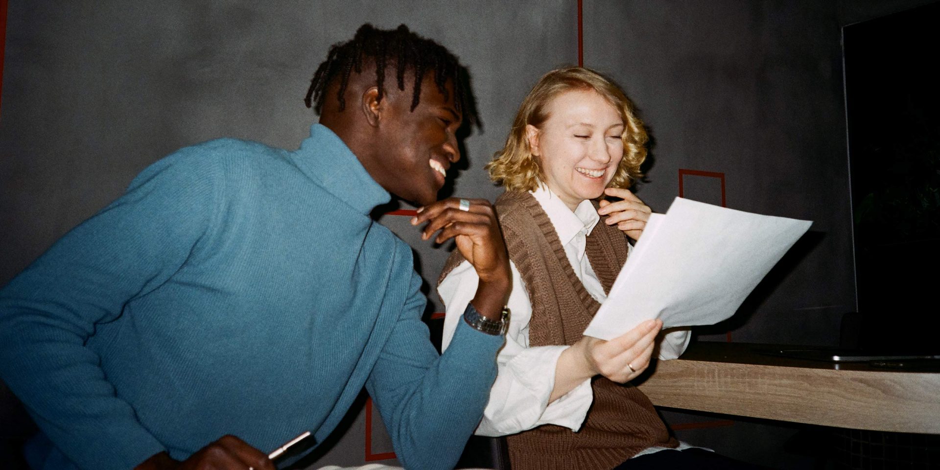 Ein Mann und eine Frau schauen sich einen Ausdruck mit den norisbank-Konditionen an.