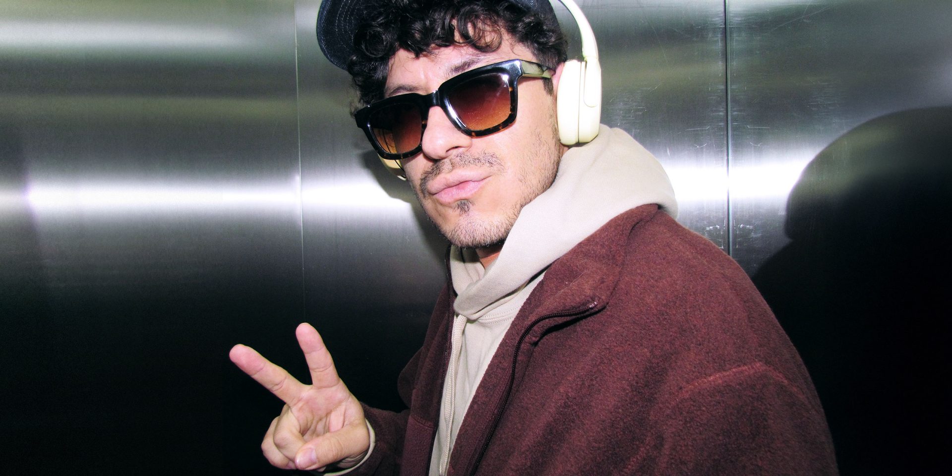 Mann mit Sonnenbrille zeigt das Victory-Zeichen symbolisch für "2-Faktor-Authentifizierung", ein norisbank Sicherheitsverfahren.