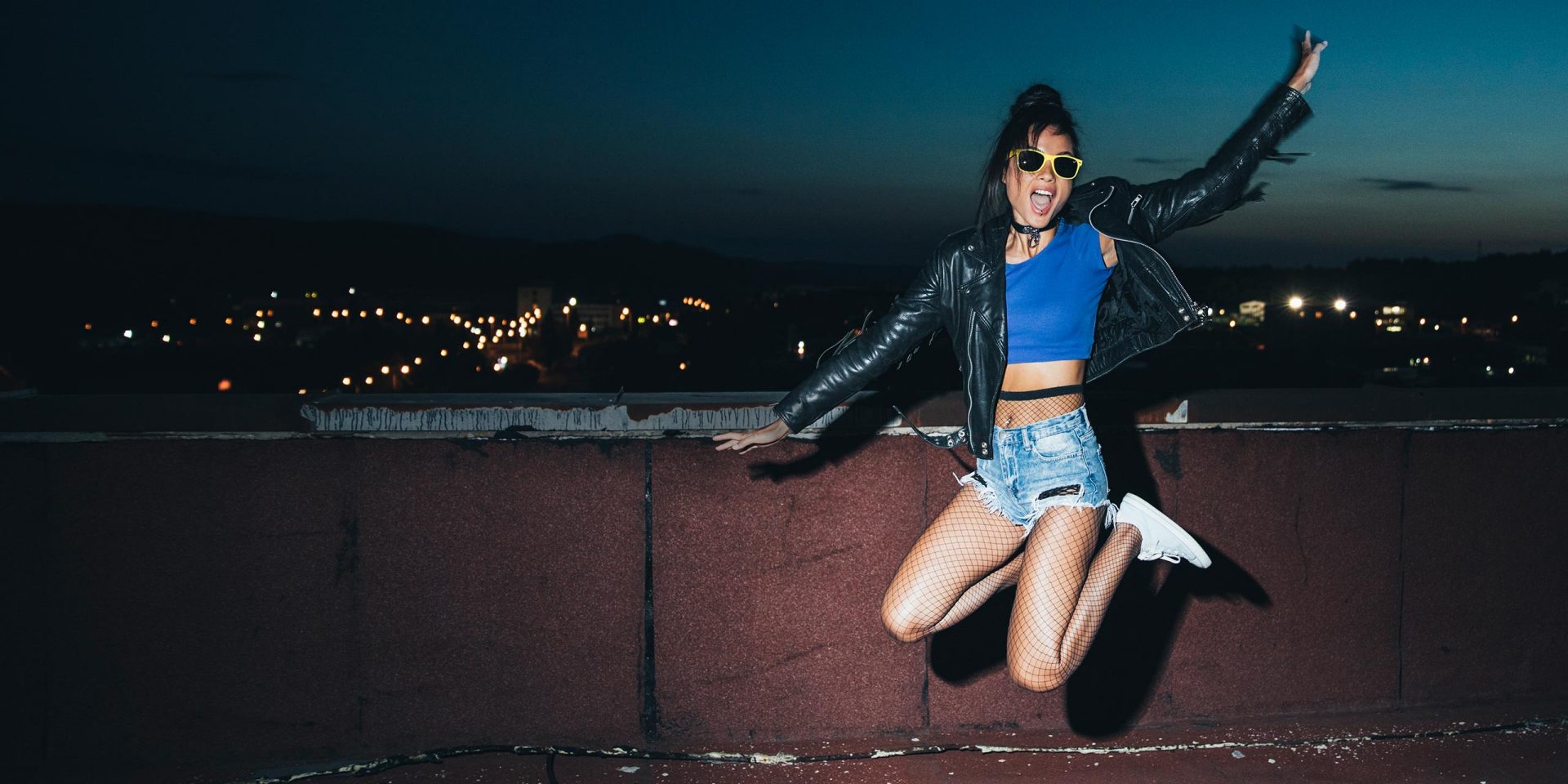 Fröhliche junge Frau springt in die Luft. Symbolbild für "Tagesgeldkonto".