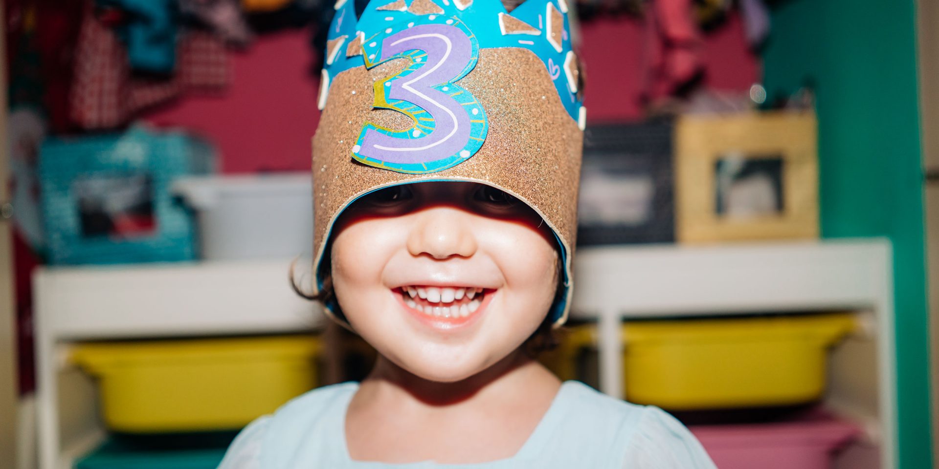 Nahaufname eines Kindes mit einer Krone auf dem Kopf. Symbolbild für "Tagesgeldkonto für Kinder"