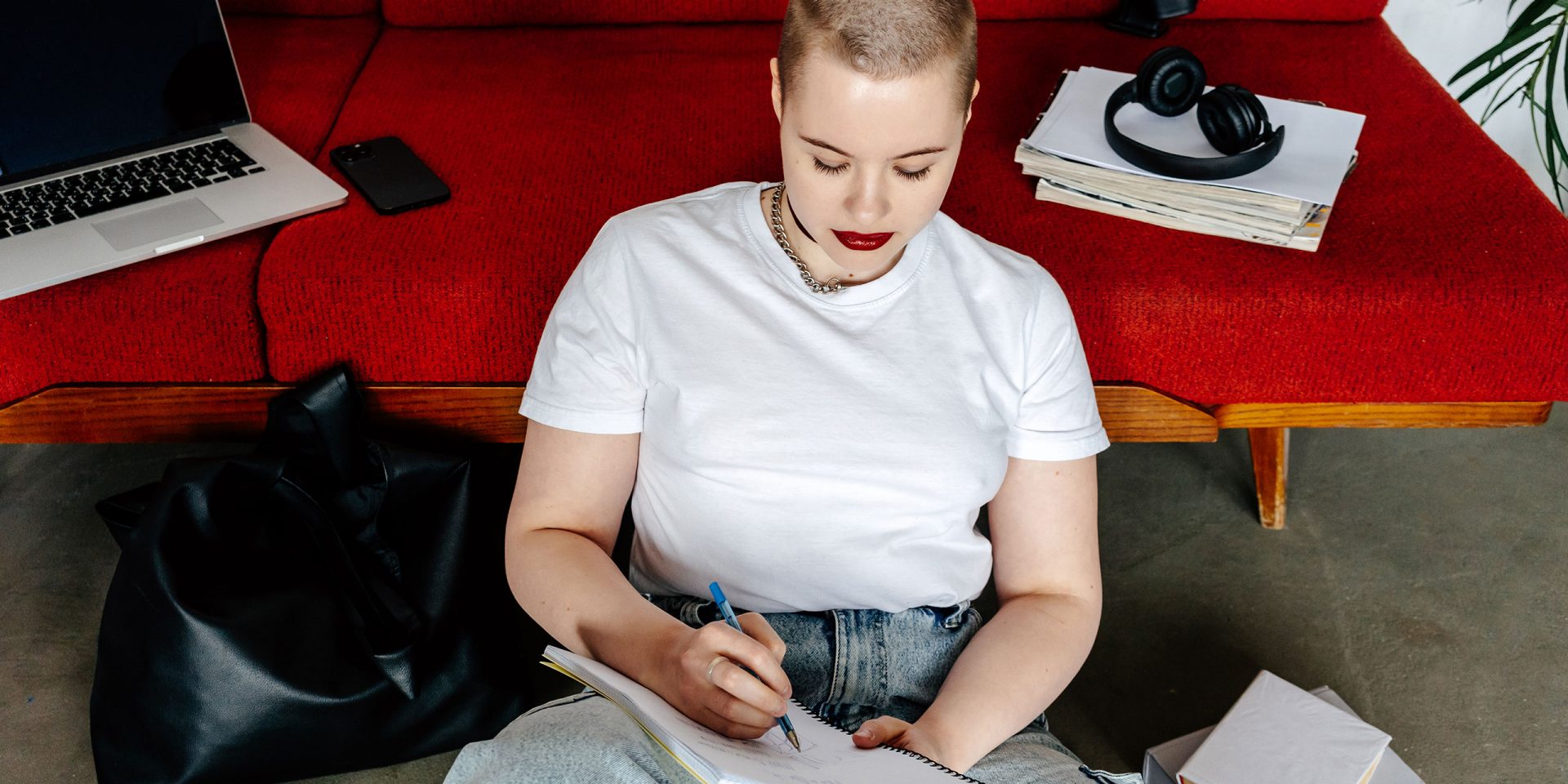 Person schreibt Notizen neben Laptop – Checkliste für "Was braucht man um ein Konto zu eröffnen".