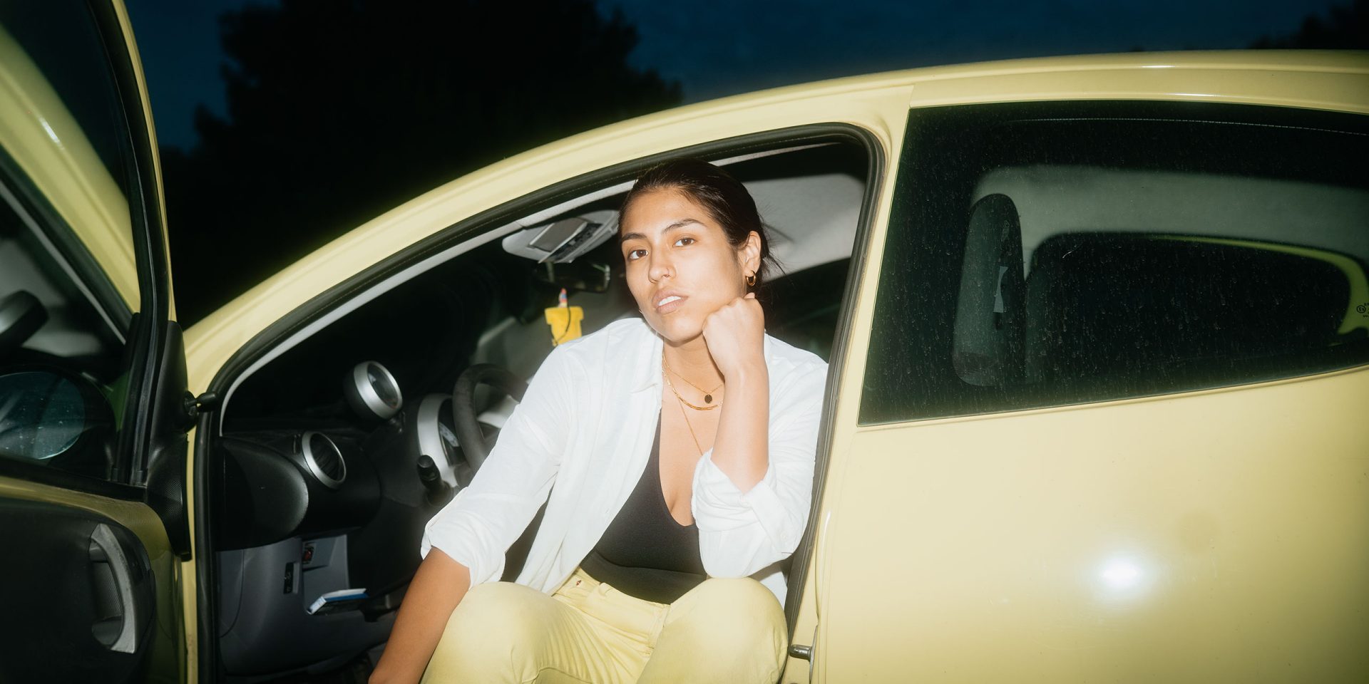 Wieviel Kredit bekomme ich, zum Beispiel für ein Auto? Aufnahme einer jungen Frau auf dem Fahrersitz eines Autos