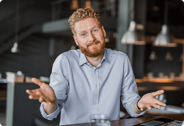 Mann macht eine fragende Geste mit seinen Händen