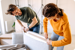 Junges Paar hat mit einem Privatkredit Möbel gekauft und zieht in erste gemeinsame Wohnung 