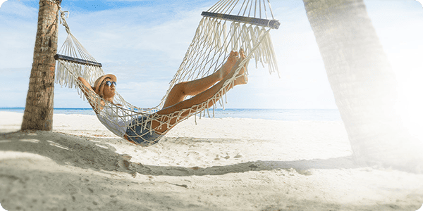 Mann in Hängematte, der Dank seines Ratenkredits in den Urlaub kann